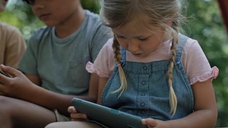 Cerca-De-Una-Niña-Mirando-Un-Teléfono-Móvil-En-El-Patio-De-Recreo.