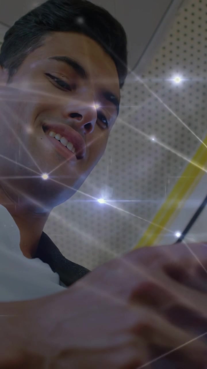 Video verticale: Uomo che guarda in basso, usa il telefono leggendo in treno, stelle che si allineano al viso, sorridendo.