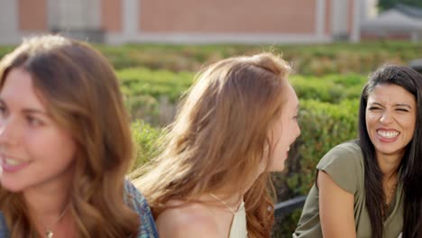 two women laughing and enjoying a conversation outdoors