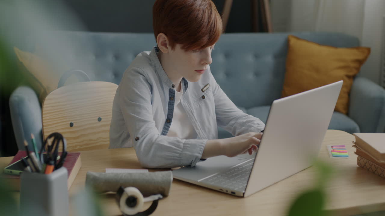Teenage Boy Working on Laptop at Home