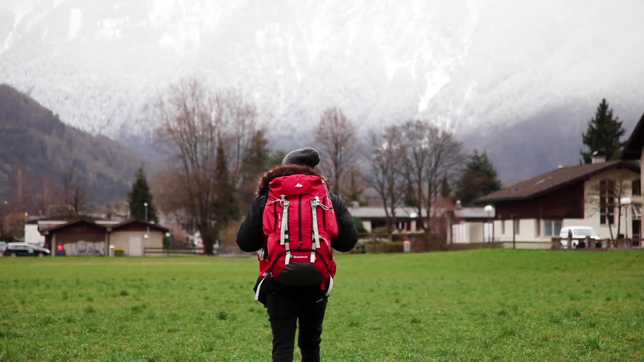스위스 초원 주변을 배낭 여행하는 나그네