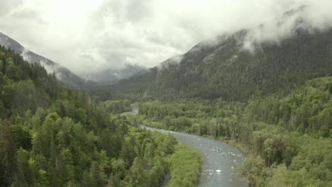 drone footage of misty and foggy pacific northwest mountains with river