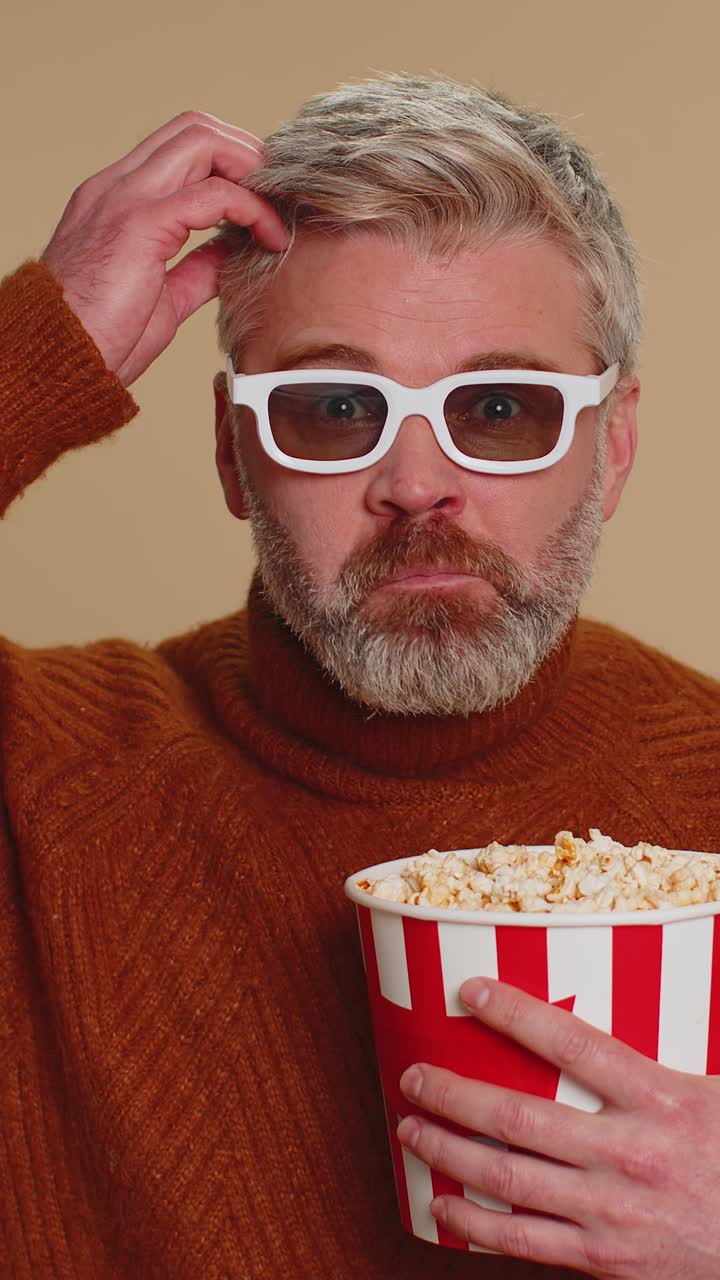 Excited man in 3d glasses eating popcorn and watching interesting tv serial sport game film movie