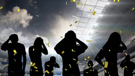 golden confetti falling over silhouette of disappointed fans and sports stadium