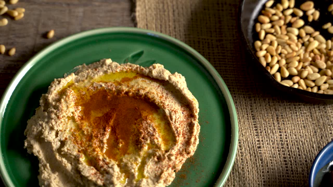 deslizamiento de alto ángulo a la izquierda de la comida del medio oriente untada con hummus, piñones, limones, aceitunas, get y ouzo o arak