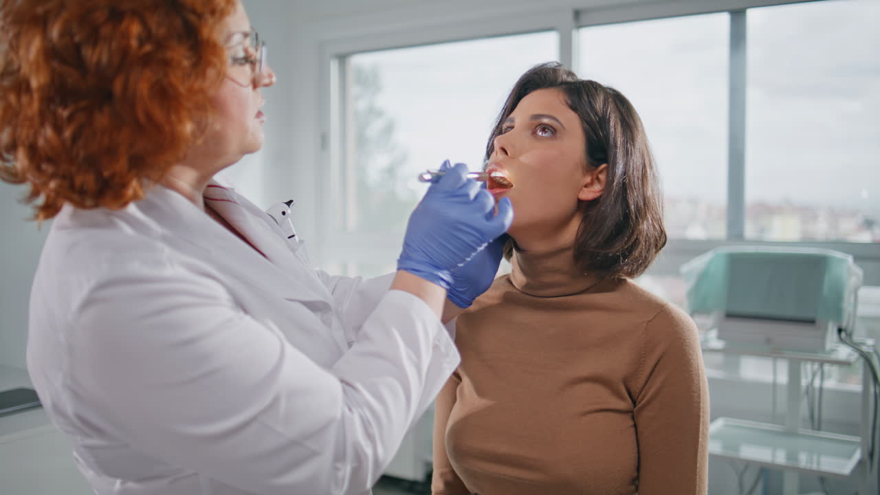 Medic examining patient throat at clinic examination closeup. Health checkup