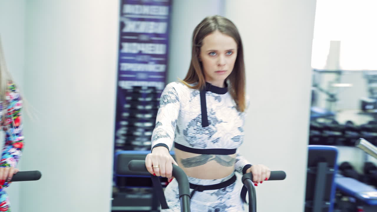 Young women cycling in the gym. Close up view of women working out in gym on the exercise bike