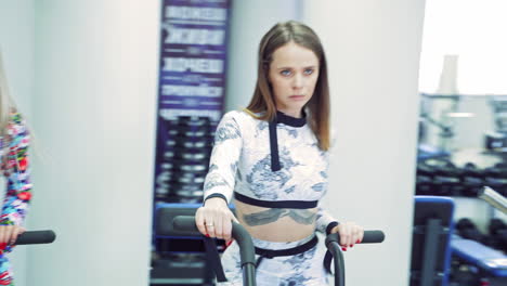young women cycling in the gym. close up view of women working out in gym on the exercise bike