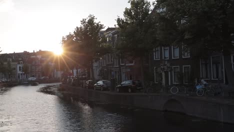 Boat-sailing-through-historic-canal-in-the-Netherlands-at-sunset