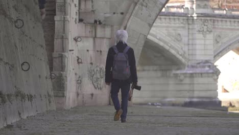 person walking along the river tiber