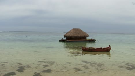 wood hut built on a boat and small fisherman boat, moorea, french polynesia