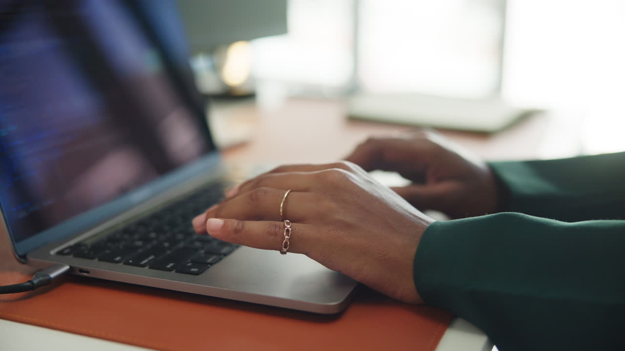 Close-up of Hands Typing on Laptop Keyboard in an Office