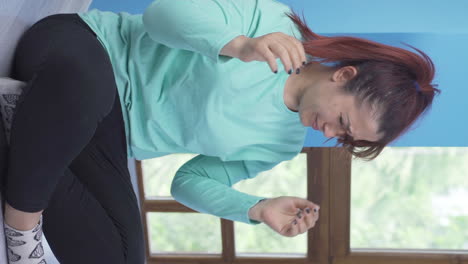 Vertical-video-of-The-woman-sitting-by-the-wall-is-angry-with-herself.