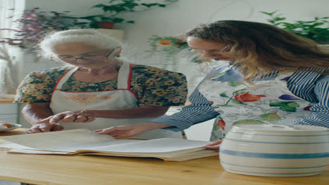 grandmother and granddaughter looking through handwritten recipe book