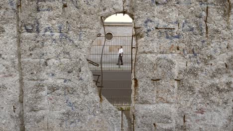 looking through a hole in berlin wall