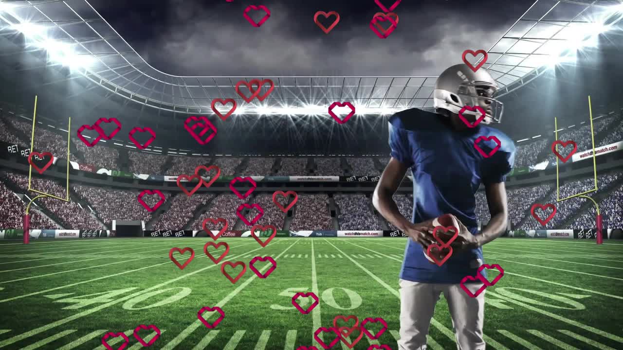 Jugador de fútbol americano parado en la línea de 50 yardas sosteniendo un balón, causando que corazones rojos floten a su alrededor