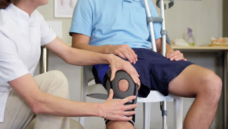 physiotherapist examining patient's knee