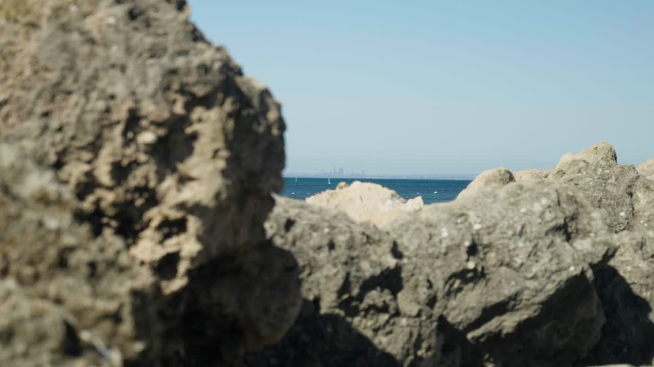 Stunning view of the Perth skyline from Rottnest Island, showcasing the city’s modern buildings against the clear sky and ocean backdrop.