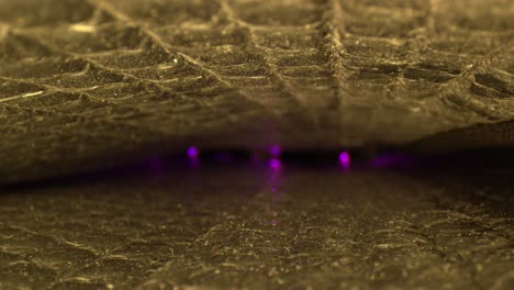 Looking-through-the-interior-of-a-reflective-car-shade-with-gold-light-on-top-and-bottom