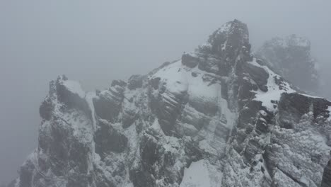 aerial shot of ninho da manta in madeira, flying over the steep cliff during a snowstorm with bad vision and sight