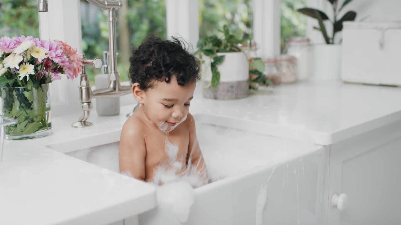 cute baby bathing funny toddler taking bath in kitchen sink having fun with soap bubbles 4k
