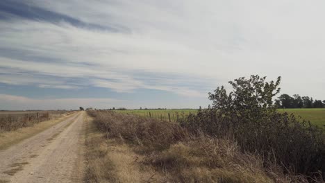 Wide-angle-landscape-view-of-a-rural-dirt-road-fading-into-the-distance