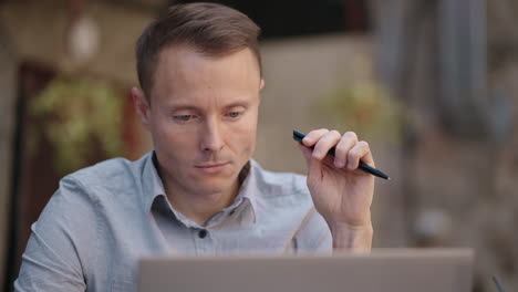 thoughtful 30s man thinking of problem solution working on laptop. serious doubtful male professional looking away at laptop considering market risks making difficult decision sitting at desk