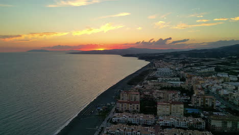 elevación del atardecer: hoteles costeros de málaga y cielo amarillo lejano capturado por un avión no tripulado