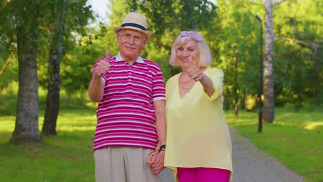 senior stylish couple grandmother grandfather looking approvingly showing thumb up like sign gesture