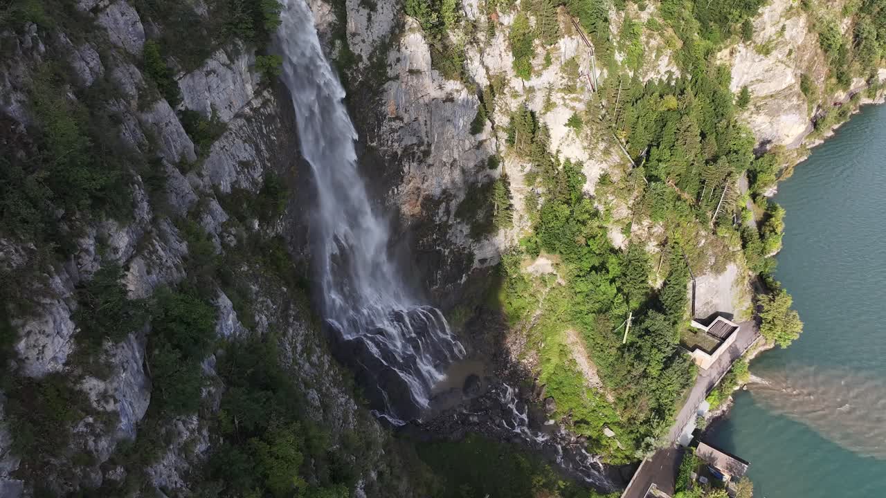 Vista aerea di una cascata con acqua limpida che cade nella valle e nel Lago Walensee. La natura svizzera è una destinazione turistica
