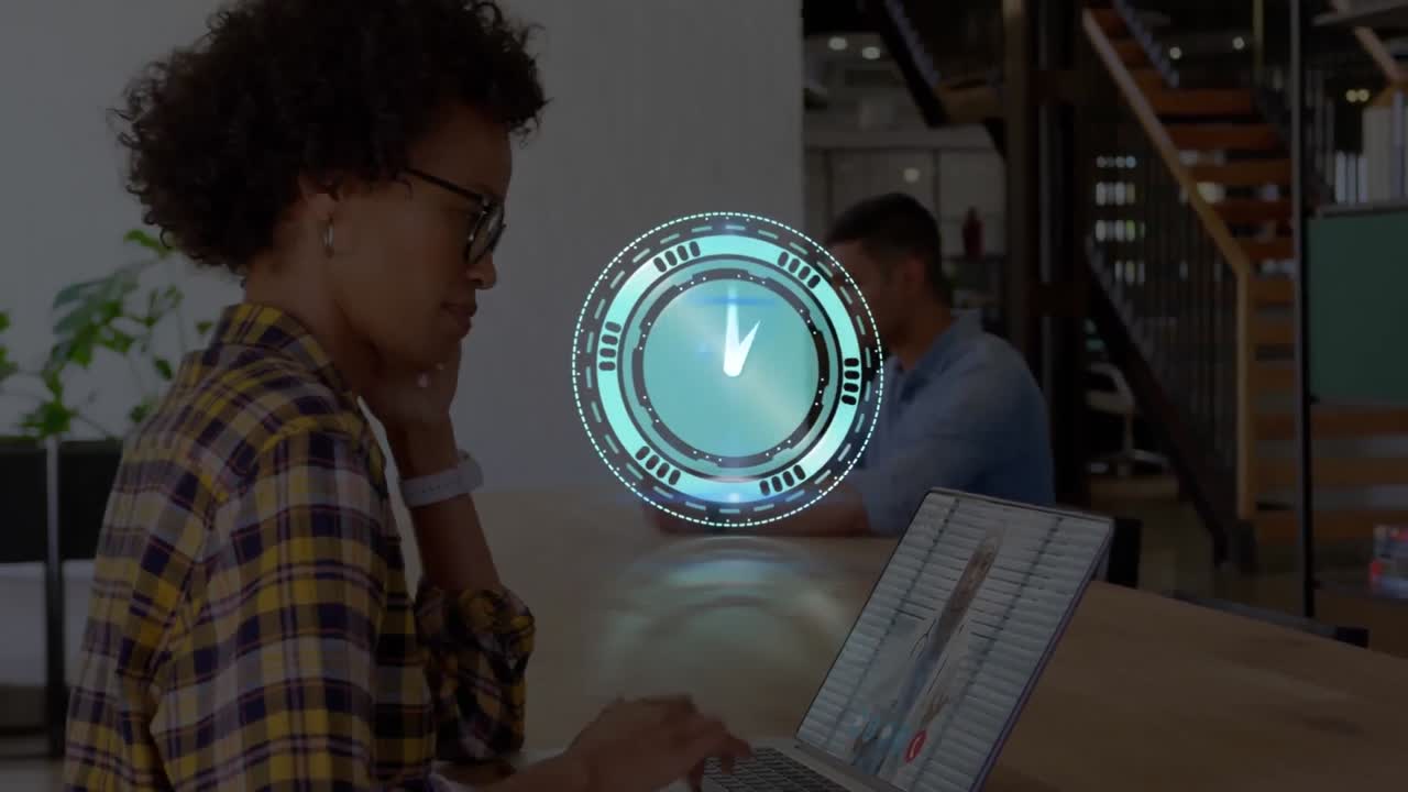 Animation of clock over african american businesswoman having laptop video call with doctor