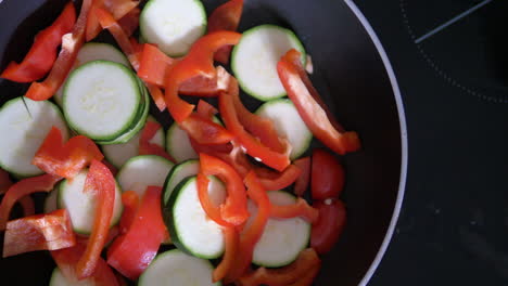 se está cocinando una sartén llena de verduras