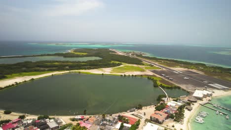 Die-Kleine-Stadt-Und-Die-Landebahn-Auf-Gran-Roque,-Los-Roques,-Venezuela,-Türkisfarbenes-Wasser,-Luftaufnahme