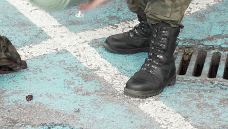 soldado enrolla la alfombra de viaje para dormir