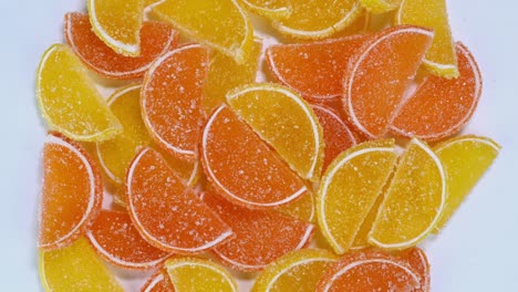 tasty orange gummy marmalade fruit jelly, sprinkled with sugar candies, rotate slowly.