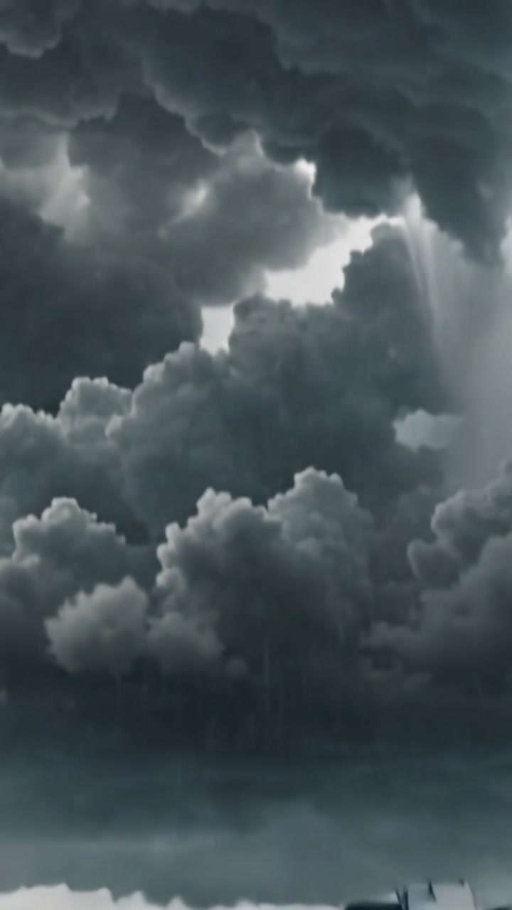 Vertical video: Pulling back, camera revealing wet urban street toward storm clouds, manhole cover