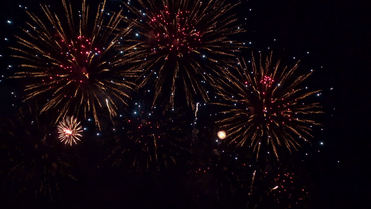 impresionante espectáculo de fuegos artificiales llena de color el oscuro cielo nocturno mientras docenas de explosiones se esparcen por la pantalla