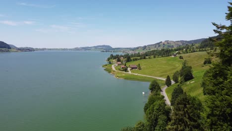 aerial shot moving through trees to reveal lake sihlsee in switzerland