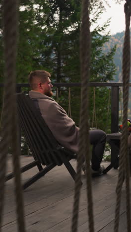 husband and wife in blankets in glamping house at twilight. couple spends vacation merging with nature in country cottage. honeymoon by mountains in autumn