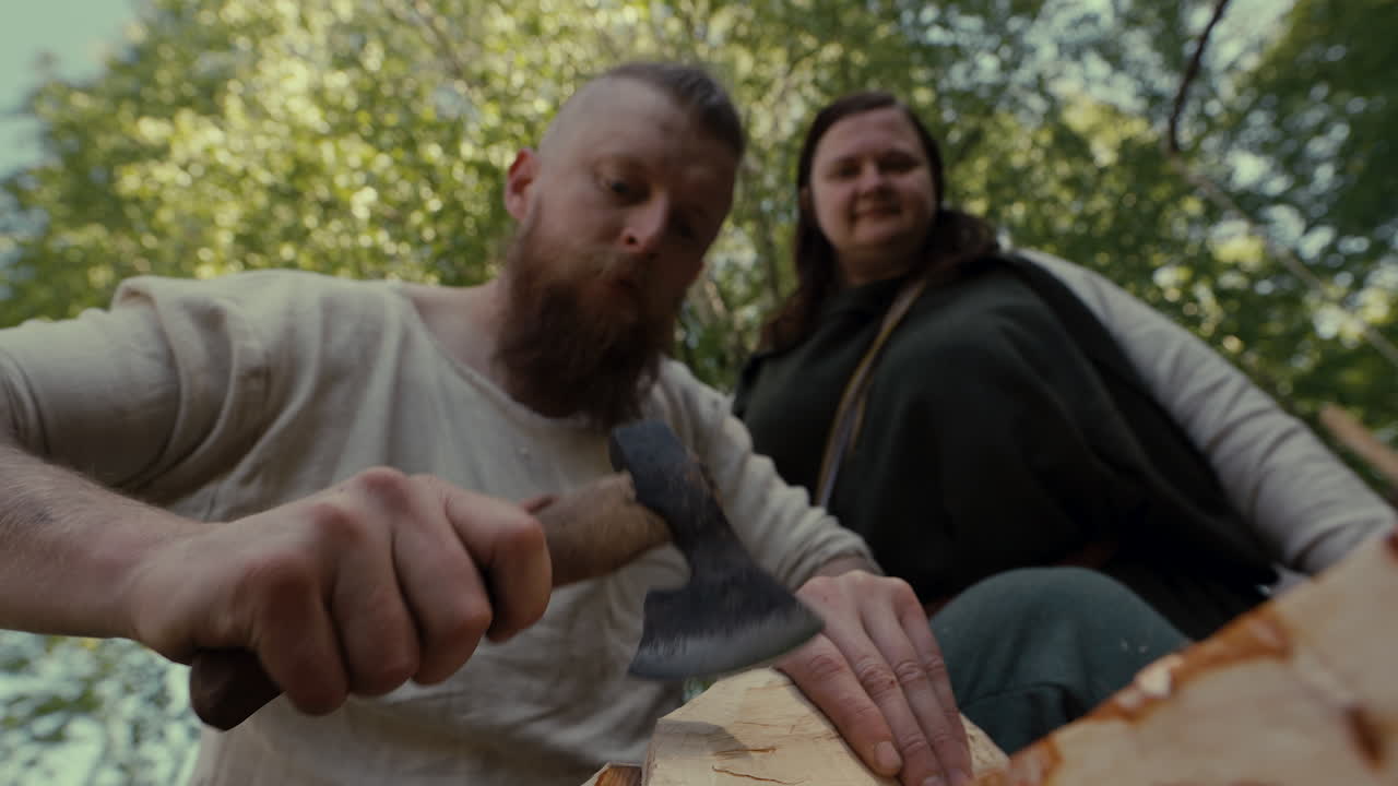 Couple Chopping Wood in a Forest Setting