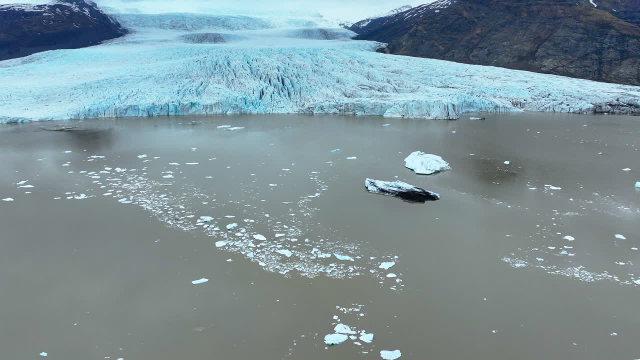 Drone footage of icebergs floating in a glacial lake in Iceland, showing climate change