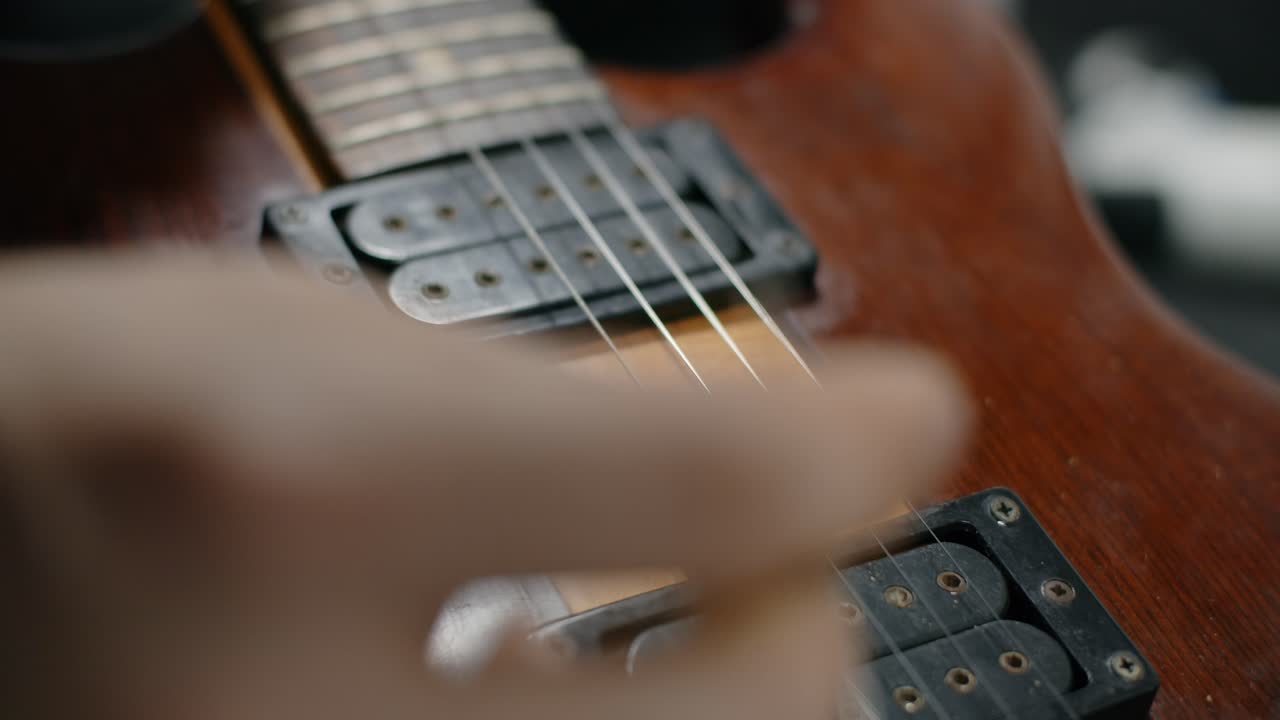 Close-up of hands playing electric guitar