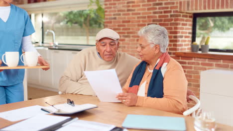 nurse discusses documents with senior couple