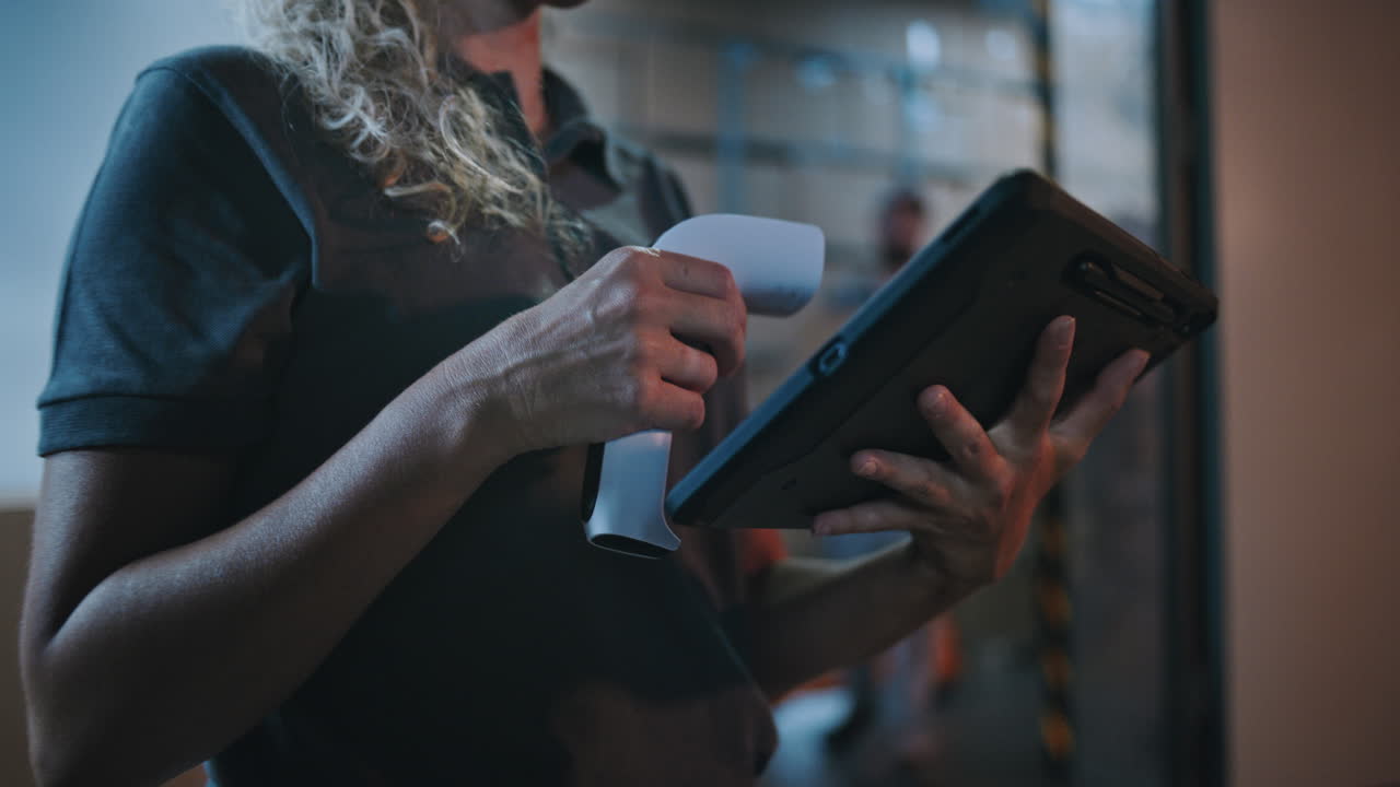 Close Up of Female Manager Scanning Parcels with Barcode Scanner Using Digital Tablet Working at