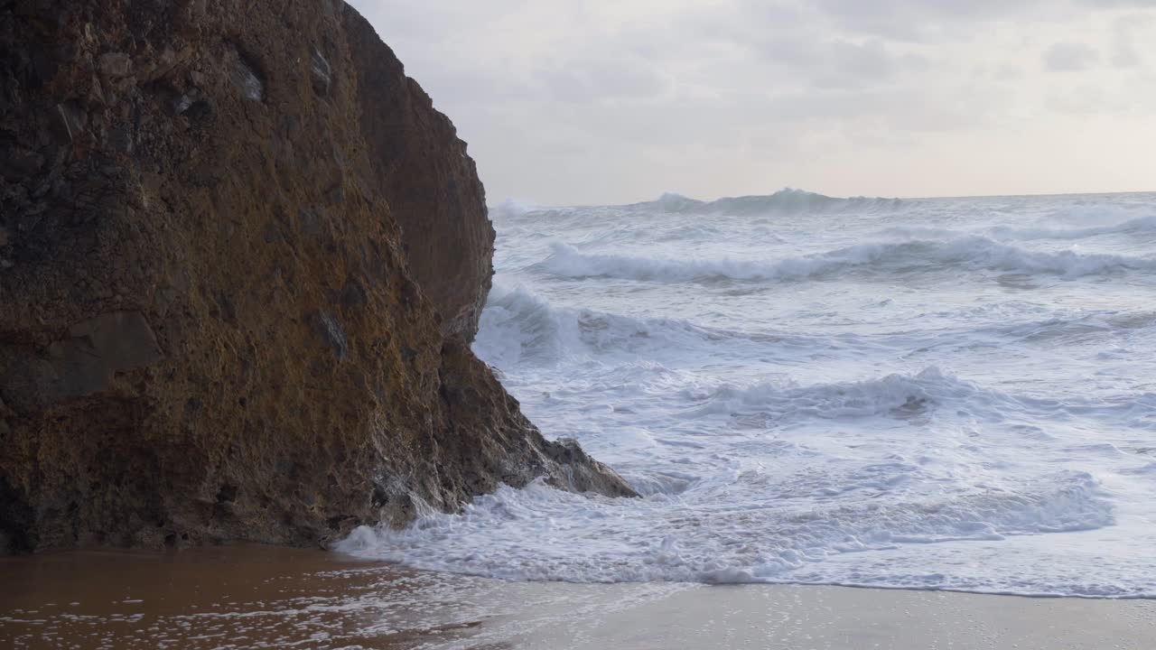 olas violentas que se estrellan en una playa de praia da adraga en portugal