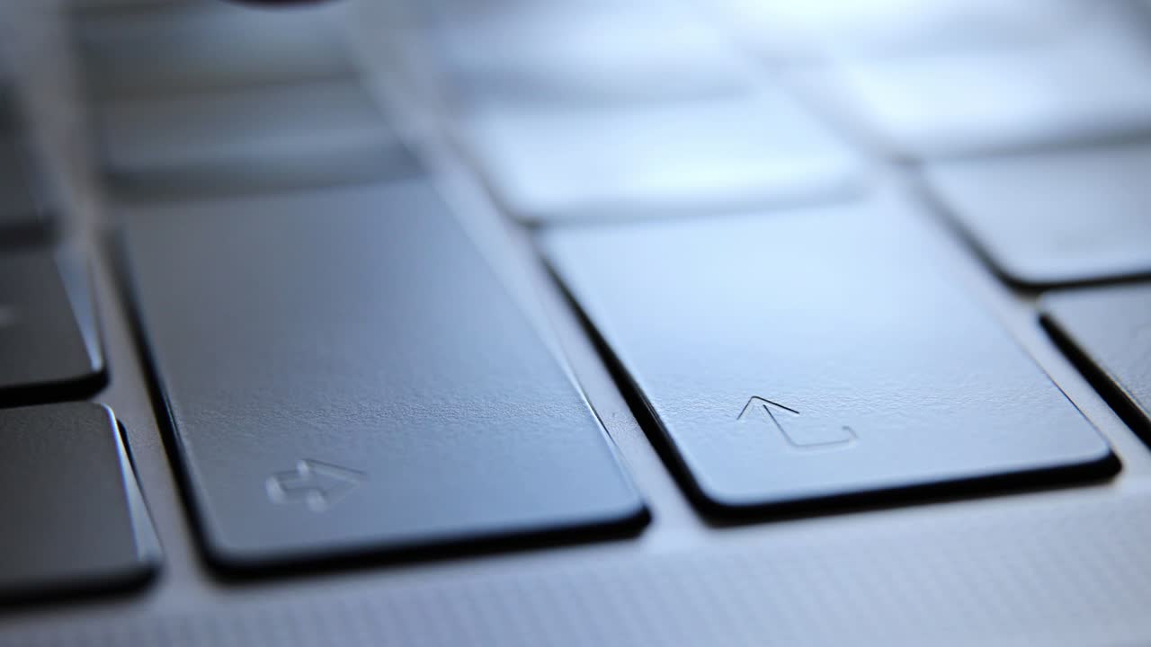 Close up of man hands typing and enter key on a laptop computer keyboard.