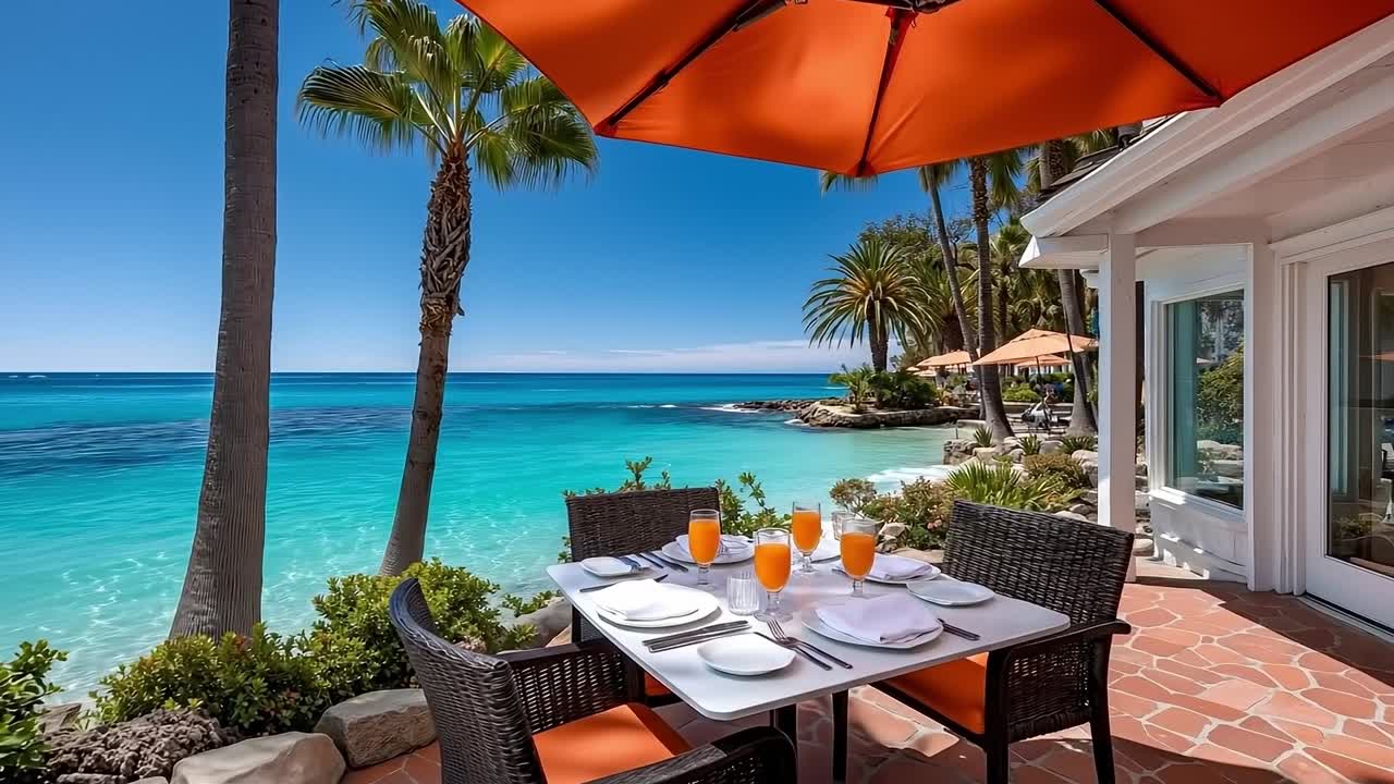 A table set for a meal on a patio overlooking the ocean