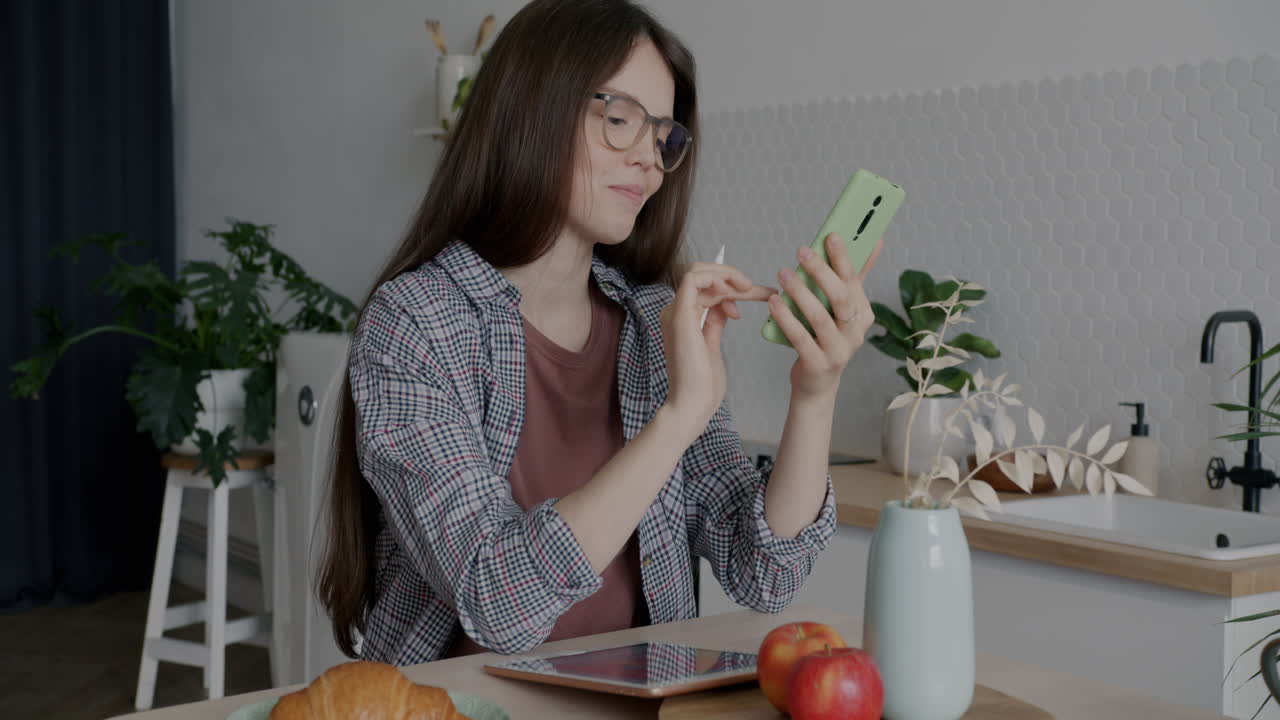 mujer usando el teléfono durante el desayuno