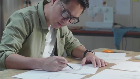 primer plano de un hombre asiático dibujando un bolso de mano en el diseño de la fianza en la oficina