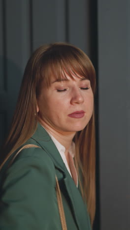 tired woman with straight red hair enters dark flat. young female returned home with packages of food in evening. businesswoman rests after work closeup